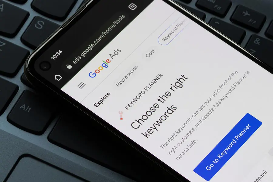 Smartphone mit Google Ads auf dem Bildschirm und Tastatur-Hintergrund