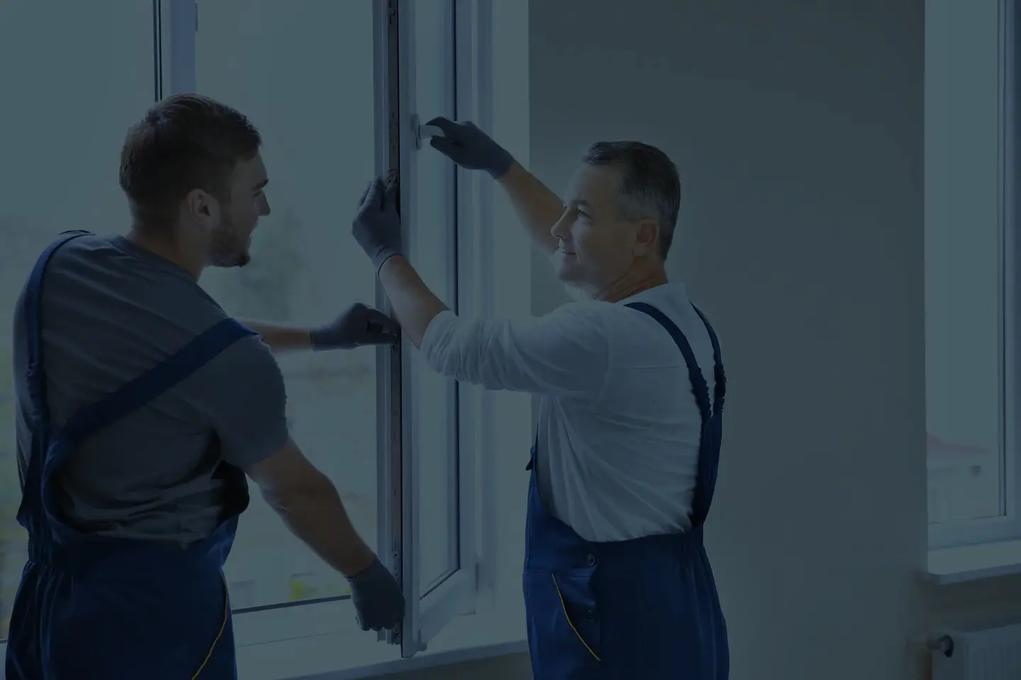 Zwei Monteure setzen gemeinsam ein neues Fenster ein – authentisches Handwerksmotiv für Stellenanzeigen und Außenwerbung Koblenz
