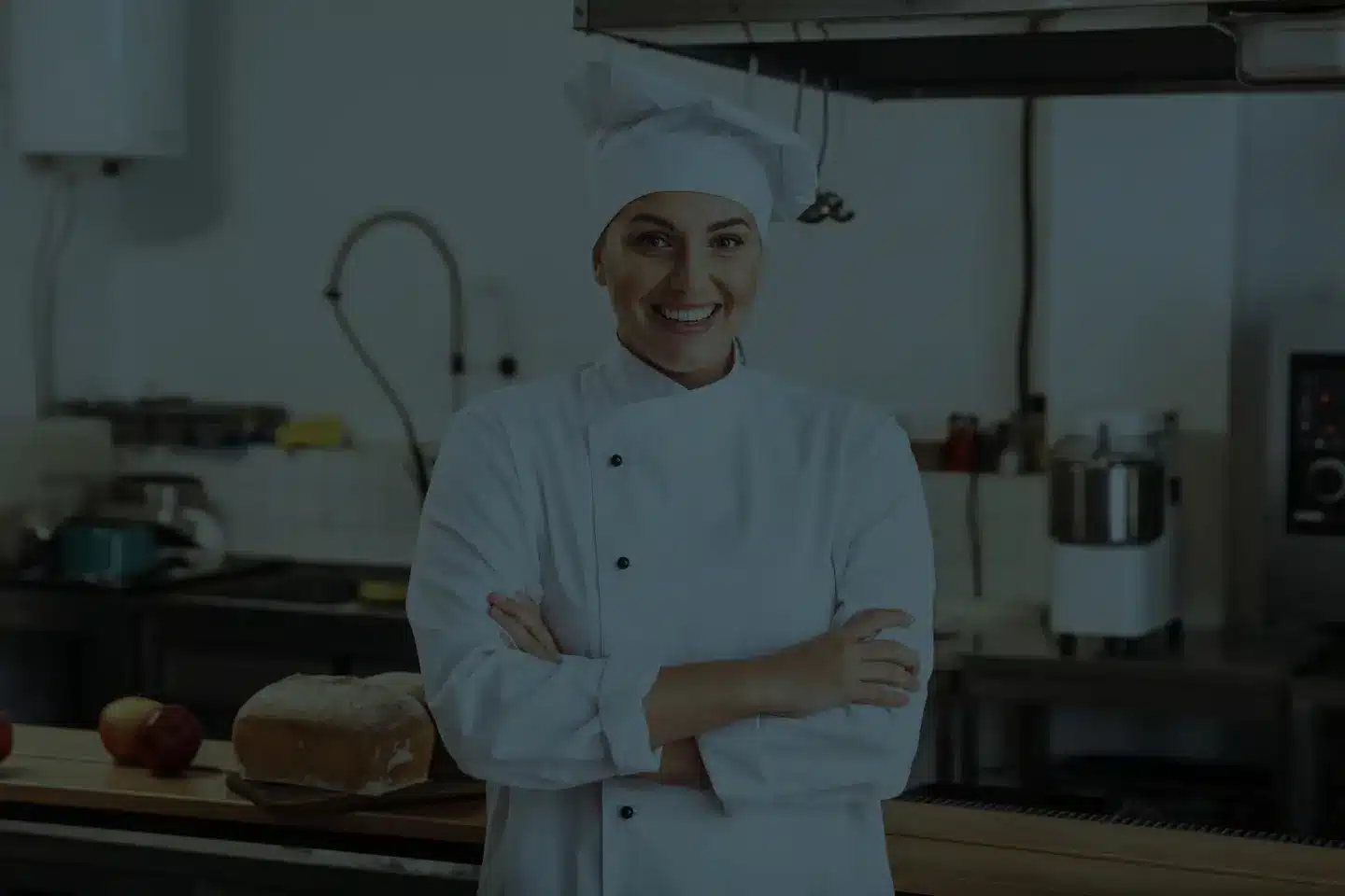 Lächelnde Köchin in weißer Uniform in Profiküche – authentisches Motiv für Gastro-Recruiting und Außenwerbung Koblenz