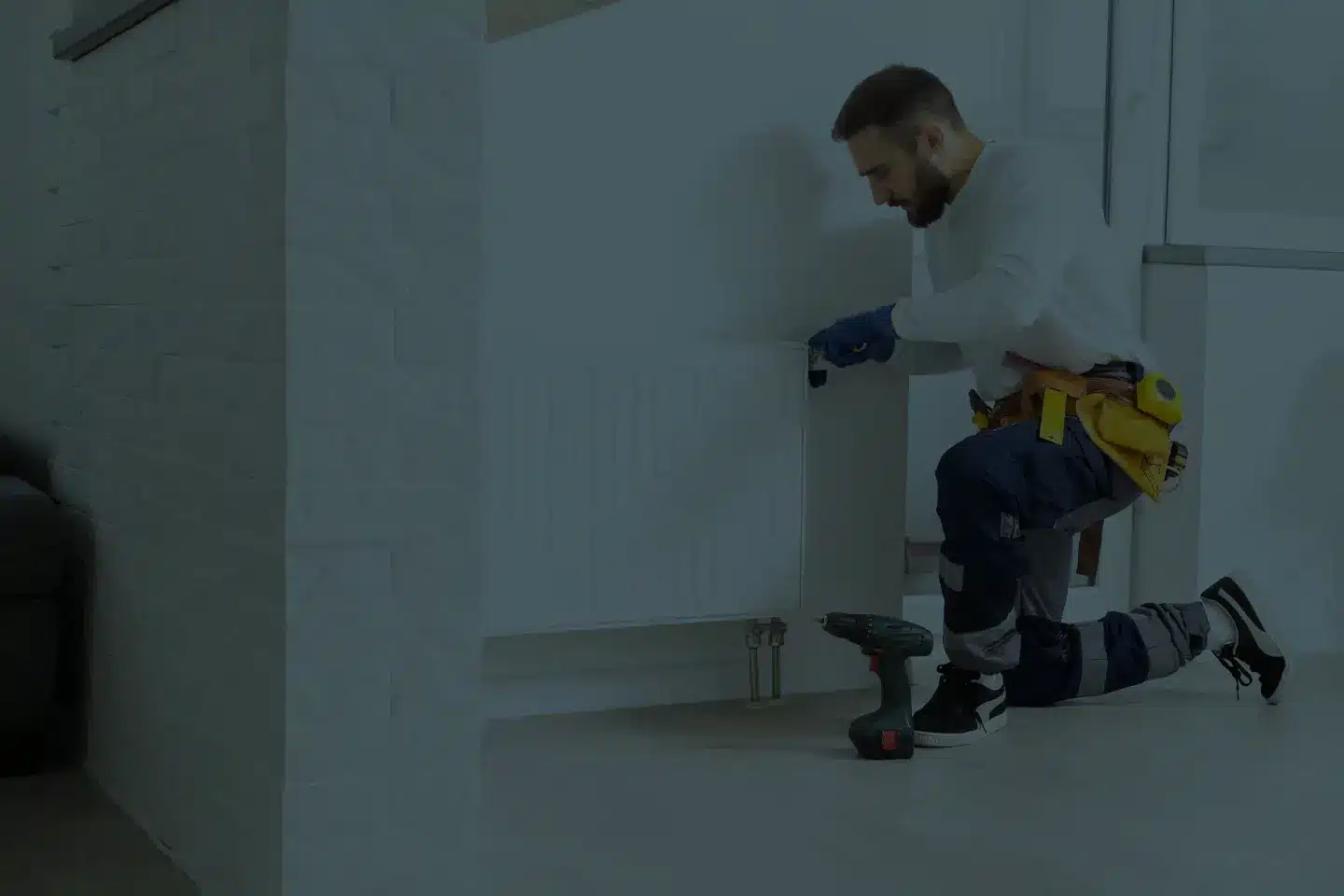 Heizungsmonteur richtet neuen Heizkörper in Wohnung aus – authentisches Handwerksmotiv für Außenwerbung Koblenz