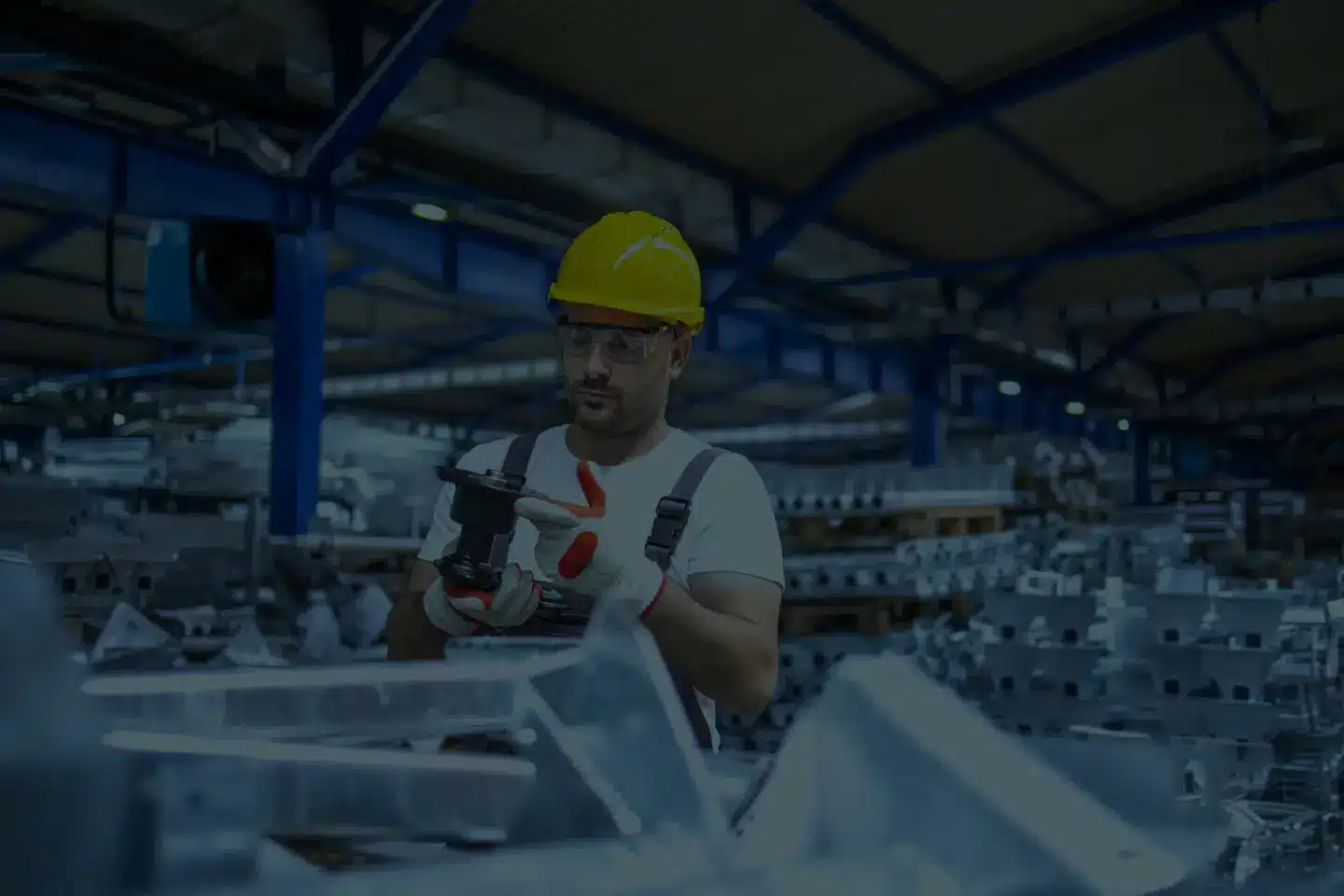 Industriearbeiter prüft Metallteil in Produktionshalle – authentisches Motiv für Stellenanzeigen und Außenwerbung Koblenz